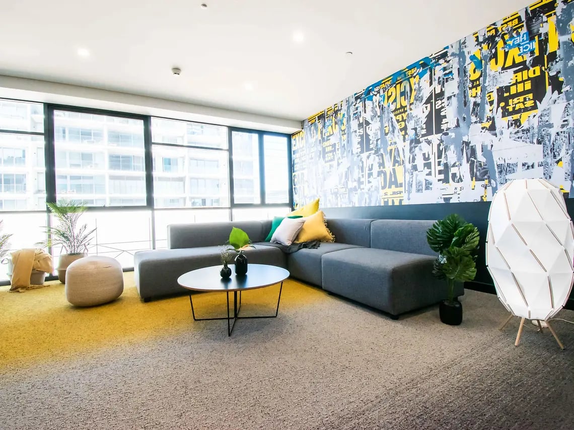 Grey sectional sofa coffee table plants stylish lamp living room at Yugo Perth City in Perth Student Accommodation