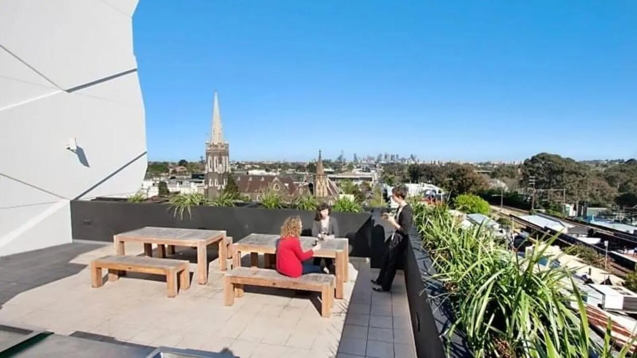 Outdoor seating area with tables and people exterior at Student Living - Vivida in Melbourne Student Accommodation