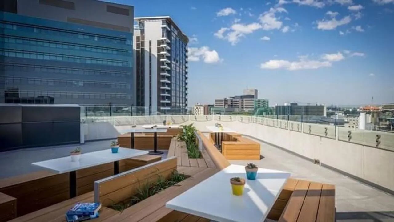 Outdoor seating area with tables and benches exterior at Student Living - Vivida in Melbourne Student Accommodation