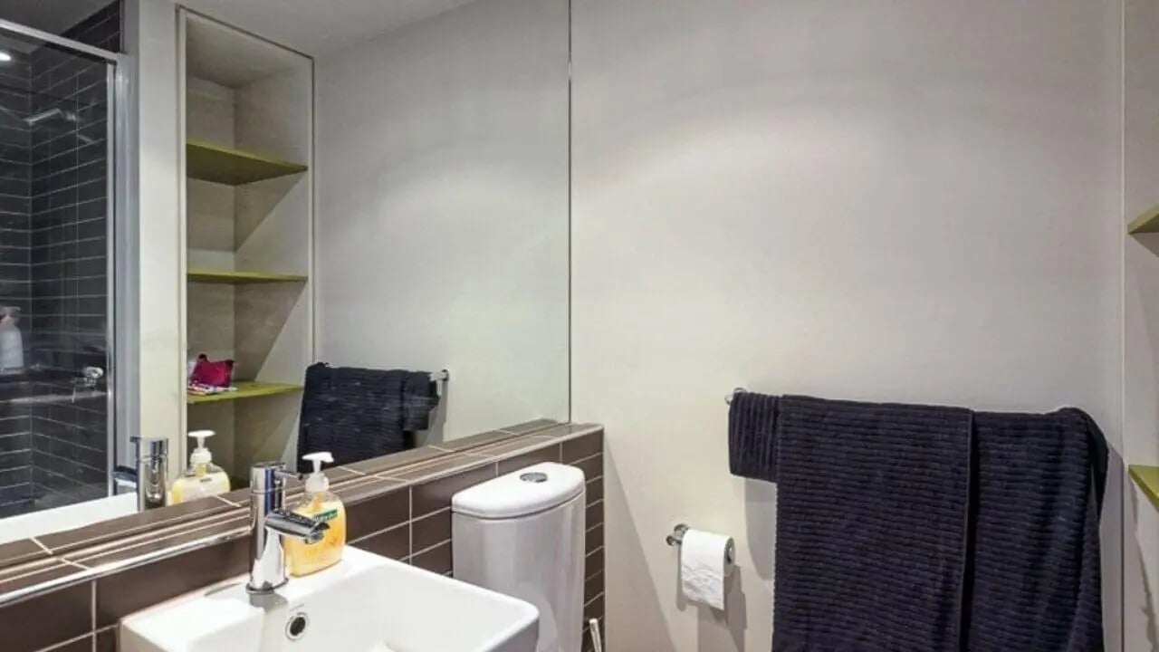 Sink toilet shelves towels shower bathroom at Student Living - Vivida in Melbourne Student Accommodation