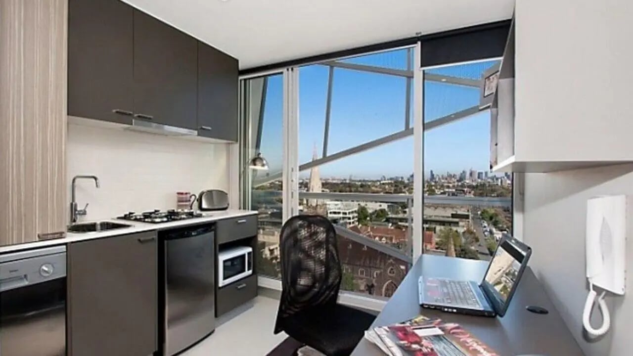 Kitchenette study desk laptop and city view study area at Student Living - Vivida in Melbourne Student Accommodation