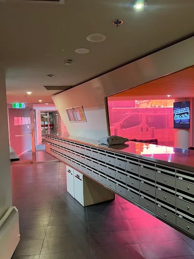 Mailboxes and a hallway with pink lighting interior. at Student Living - Vivida in Melbourne Student Accommodation