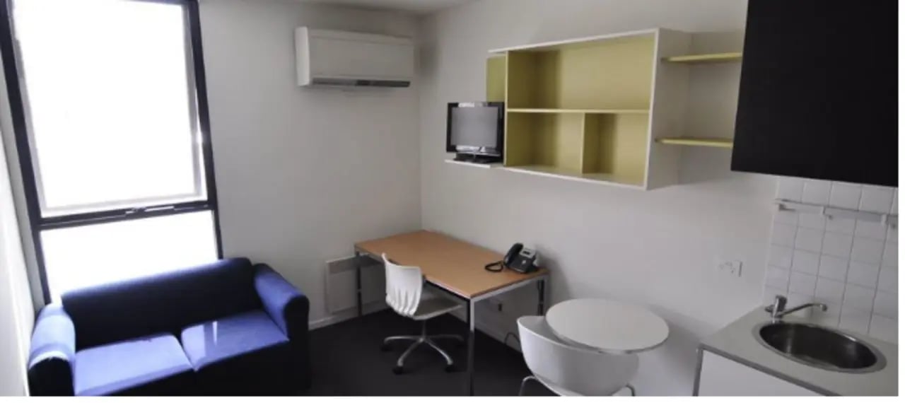 Sofa desk shelves TV kitchen sink room at Student Living On Campus in Melbourne Student Accommodation