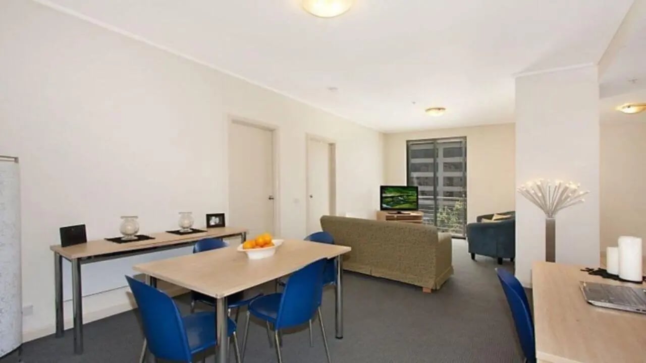 Table chairs sofa television living room at Student Living On ABeckett in Melbourne Student Accommodation