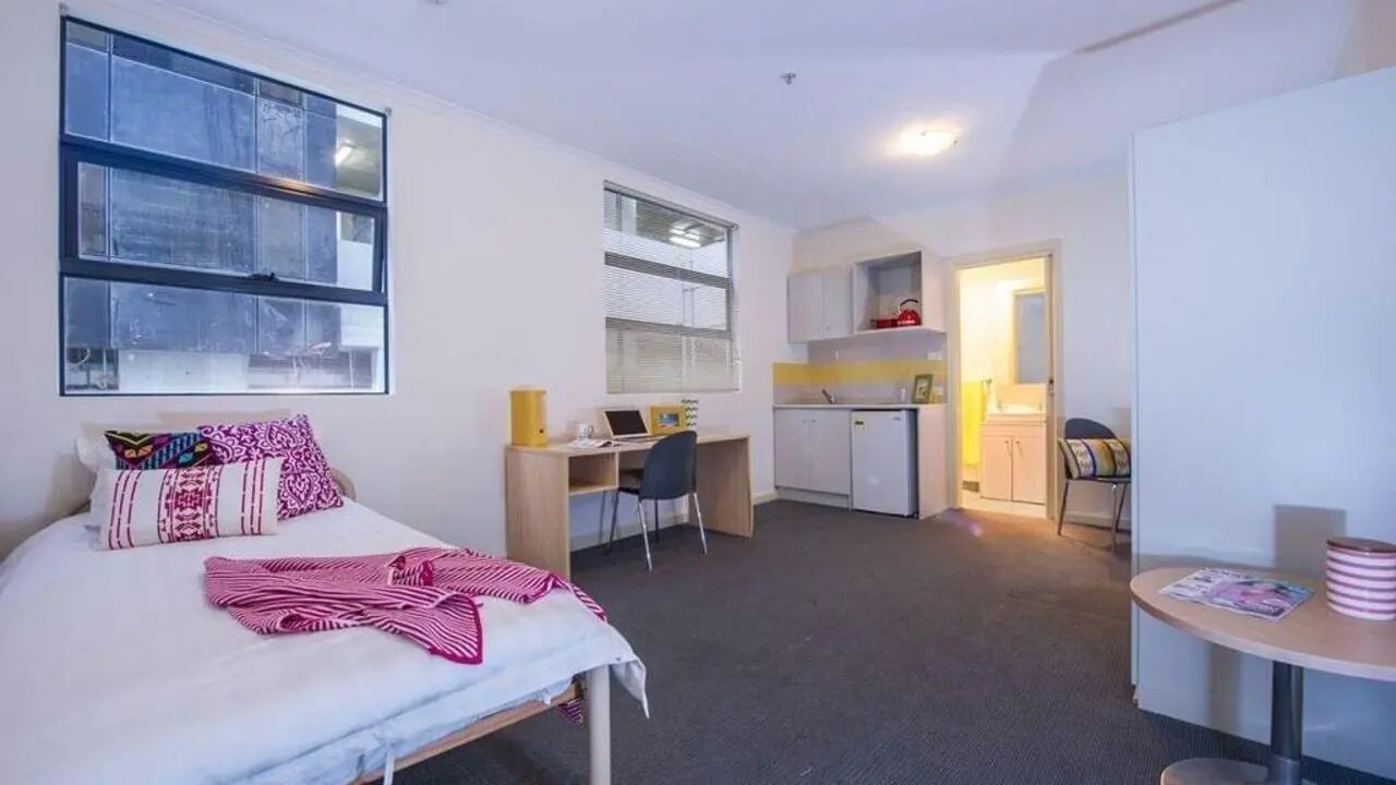 Bed desk kitchen and bathroom student studio at Student Living On ABeckett in Melbourne Student Accommodation