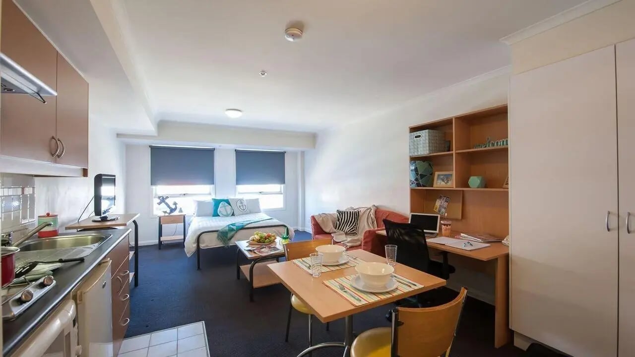 Bed desk living area kitchen studio apartment at Student Living on Flinders in Melbourne Student Accommodation