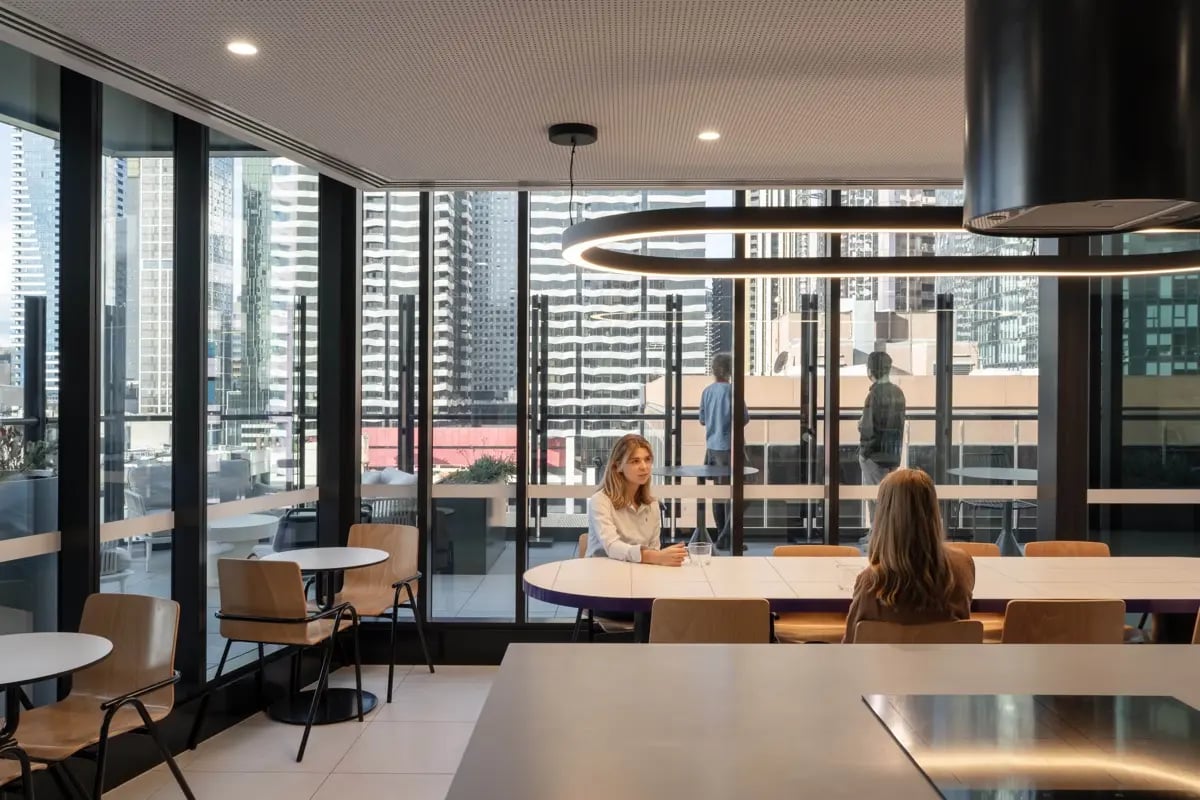 Two women at oval table city view lounge at The Switch Melbourne Victoria Market in Melbourne Student Accommodation