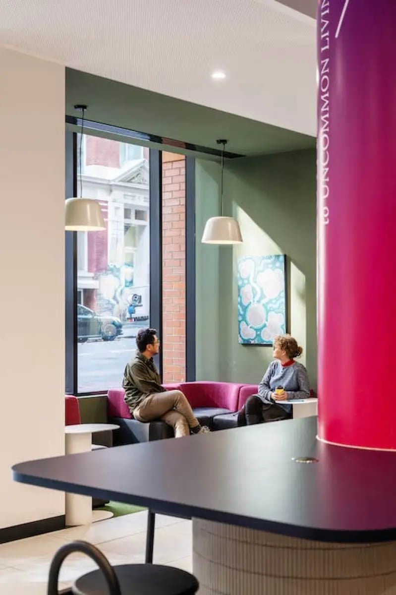 Two people on sofa next to window lounge area at The Switch Melbourne Victoria Market in Melbourne Student Accommodation