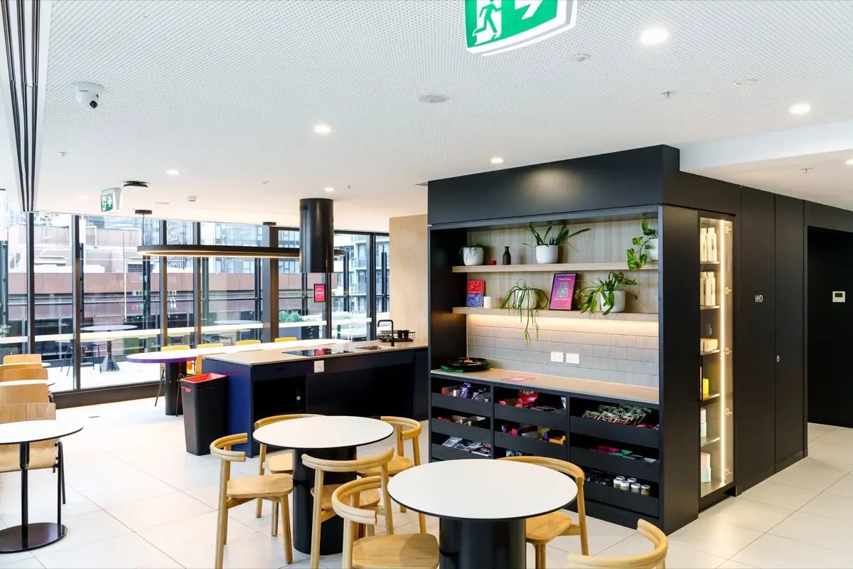 Kitchen with island tables and chairs common area at The Switch Melbourne Victoria Market in Melbourne Student Accommodation