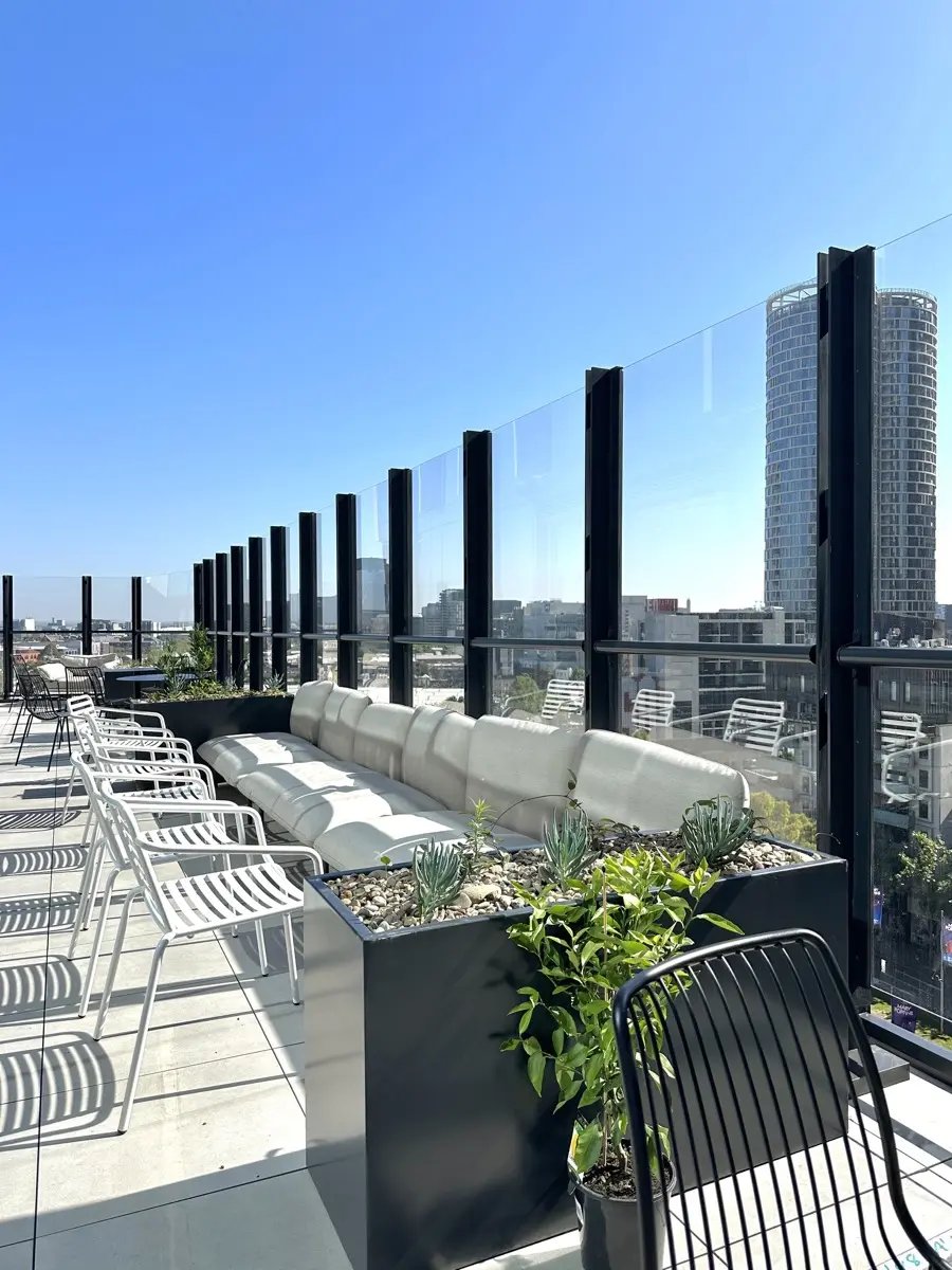 White chairs lounge and plants on rooftop patio exterior at The Switch Melbourne Victoria Market in Melbourne Student Accommodation