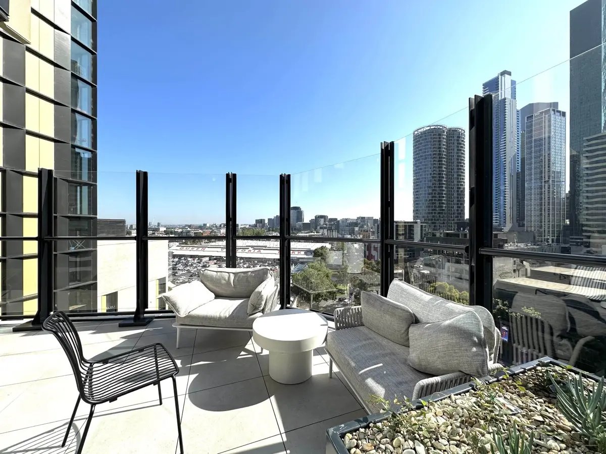 Sofa chairs table and city view balcony exterior at The Switch Melbourne Victoria Market in Melbourne Student Accommodation
