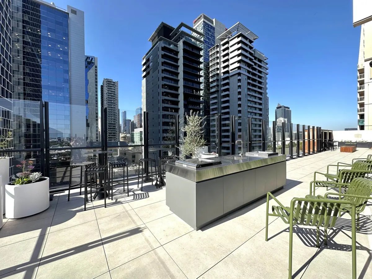 Outdoor kitchen with seating and city view exterior at The Switch Melbourne Victoria Market in Melbourne Student Accommodation