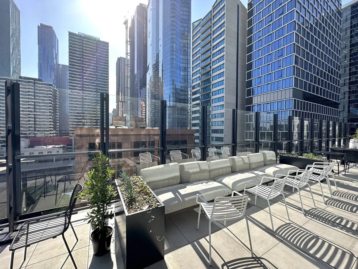 White sectional sofa and chairs on rooftop terrace exterior at The Switch Melbourne Victoria Market in Melbourne Student Accommodation