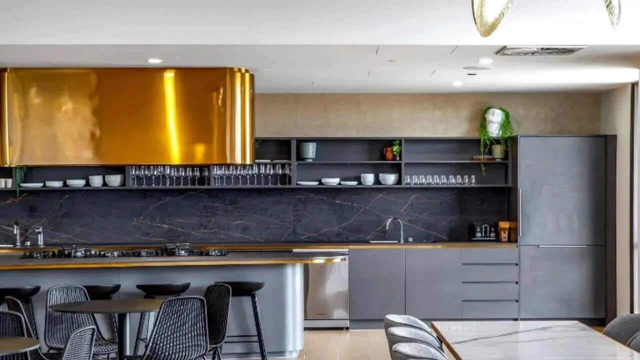 Gold range hood gray cabinets black marble counter kitchen at Realm Caulfield in Melbourne Student Accommodation