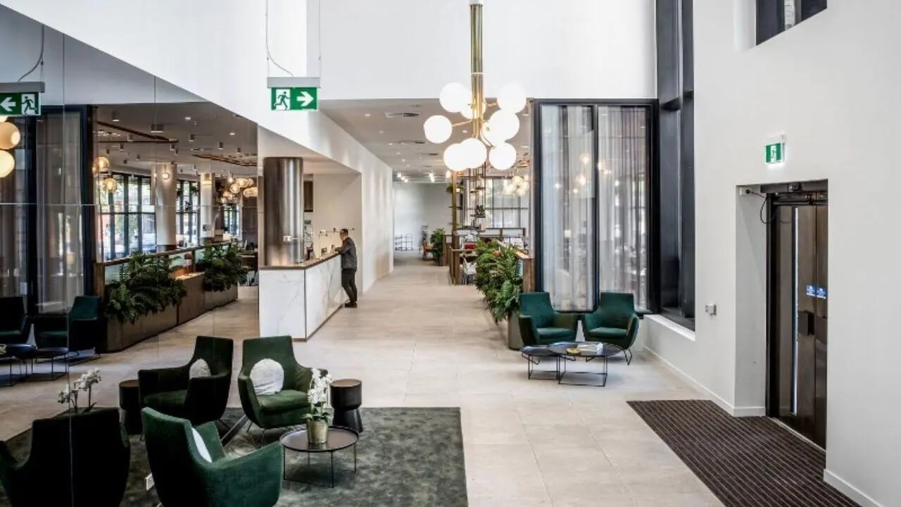 Lobby with reception desks chairs and elevator interior at Realm Caulfield in Melbourne Student Accommodation