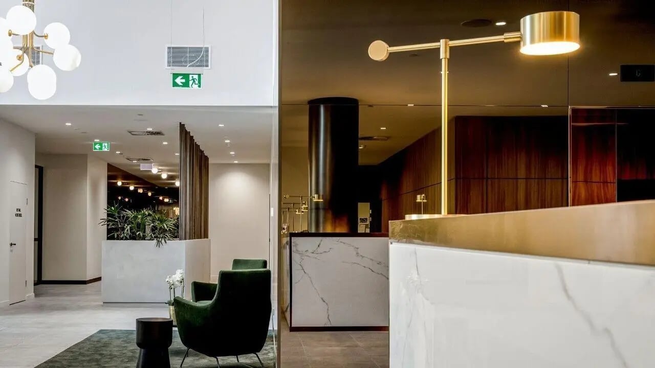 Marble reception desk with golden lamp living area at Realm Caulfield in Melbourne Student Accommodation