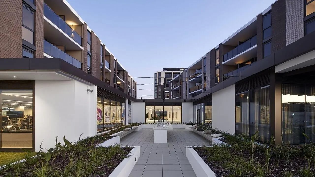 Modern courtyard with buildings glass balconies and seating exterior at Realm Caulfield in Melbourne Student Accommodation