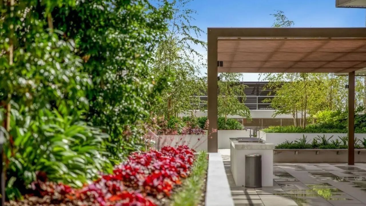 Outdoor kitchen with grill and red plants exterior at Realm Caulfield in Melbourne Student Accommodation