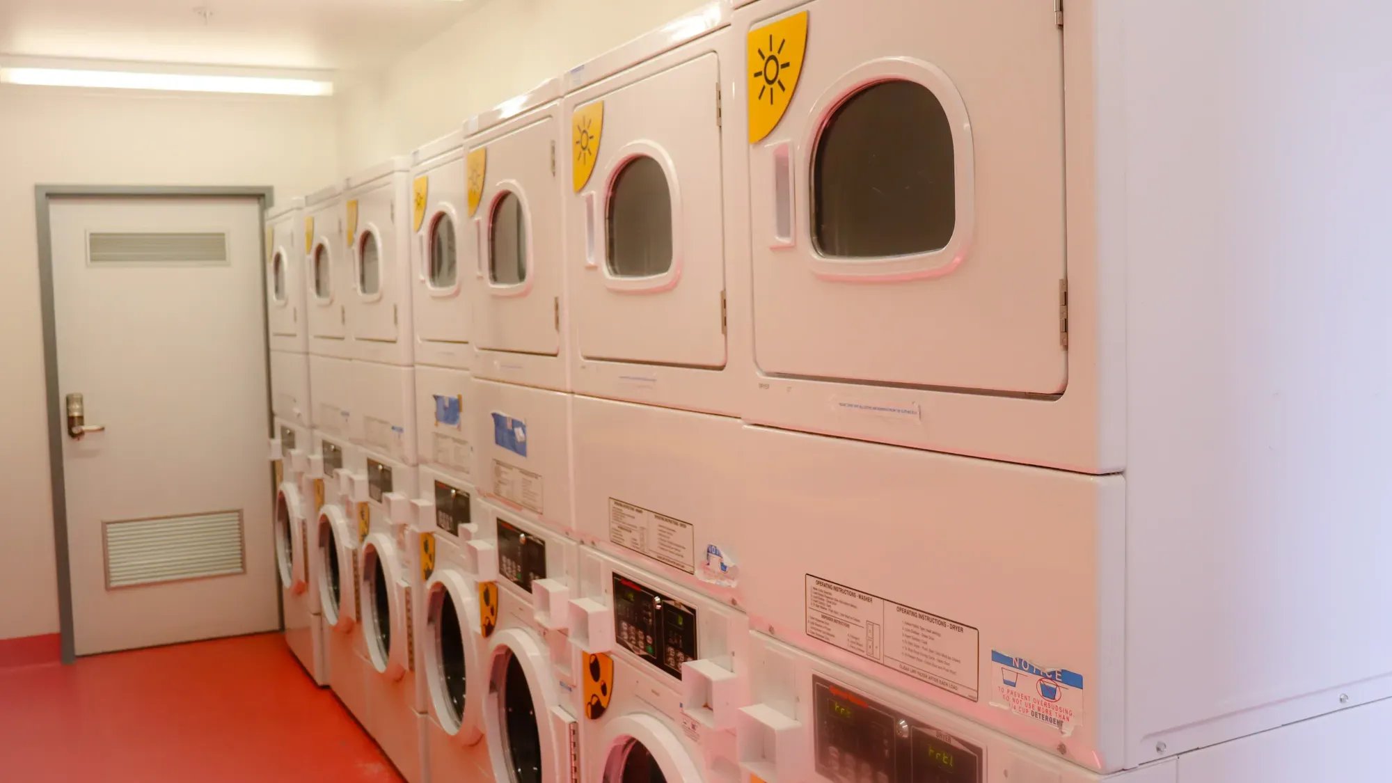Stack of white washers and dryers laundry room at La Trobe University - Hillside Apartments in Melbourne Student Accommodation