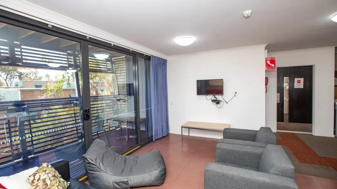 Two sofas beanbag TV and balcony living room at La Trobe University - Hillside Apartments in Melbourne Student Accommodation