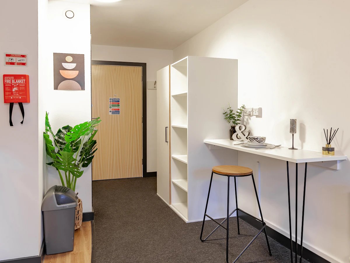 White breakfast bar with stool and shelving kitchen area at Fulham Palace Studios in London Student Accommodation