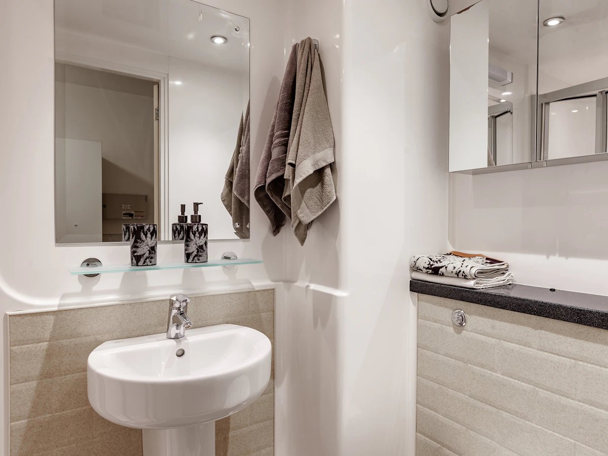 Sink mirror soap dispensers towels bathroom at Fulham Palace Studios in London Student Accommodation