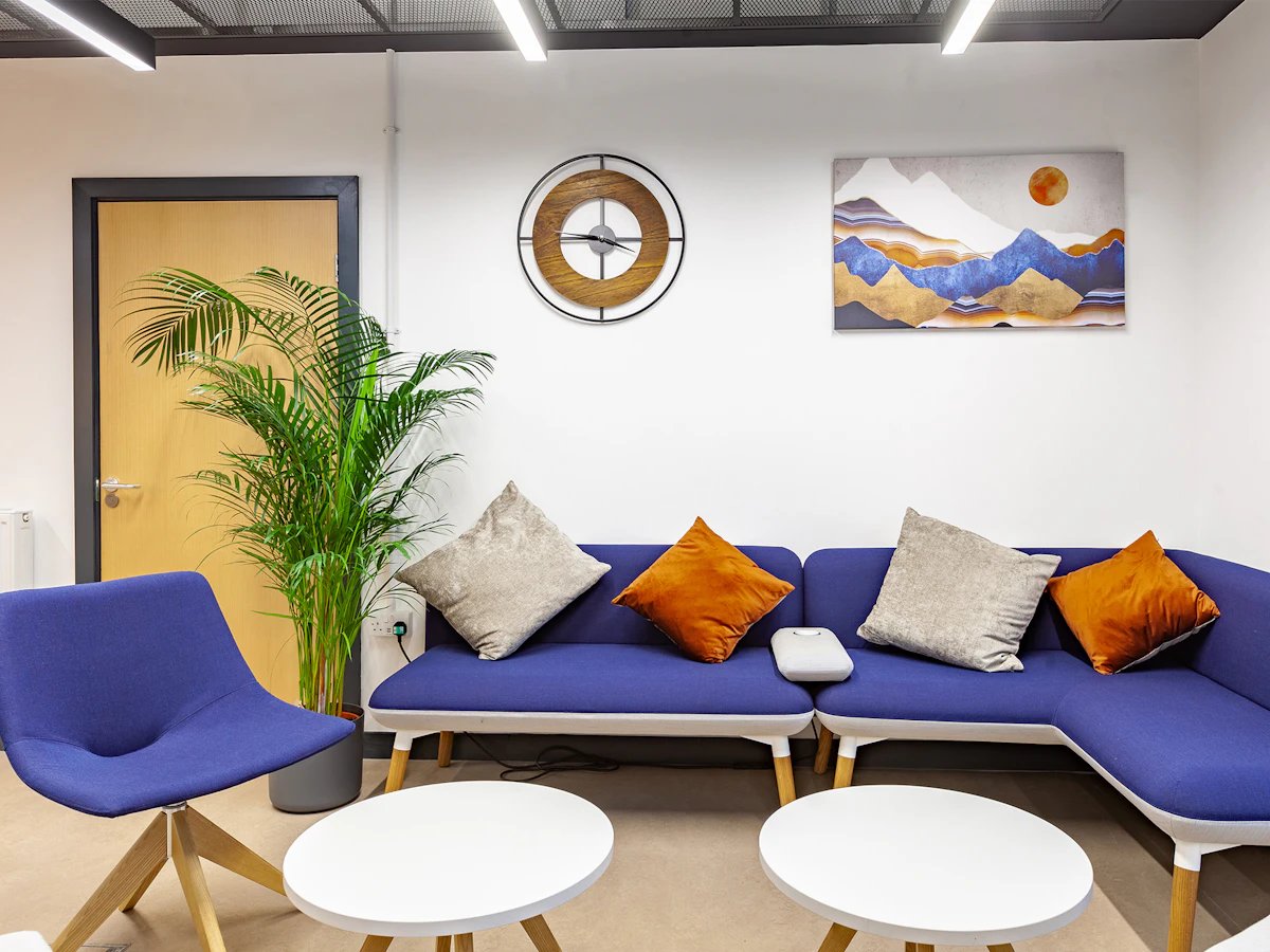 Blue sofa plant artwork and tables lounge area at Fulham Palace Studios in London Student Accommodation