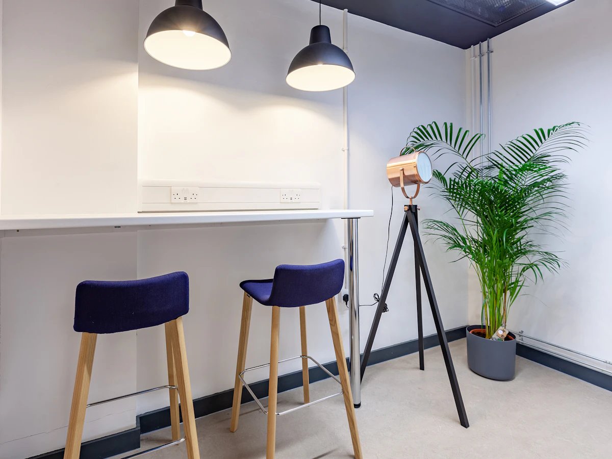 Bar stools at counter with plant and lamp study area at Fulham Palace Studios in London Student Accommodation
