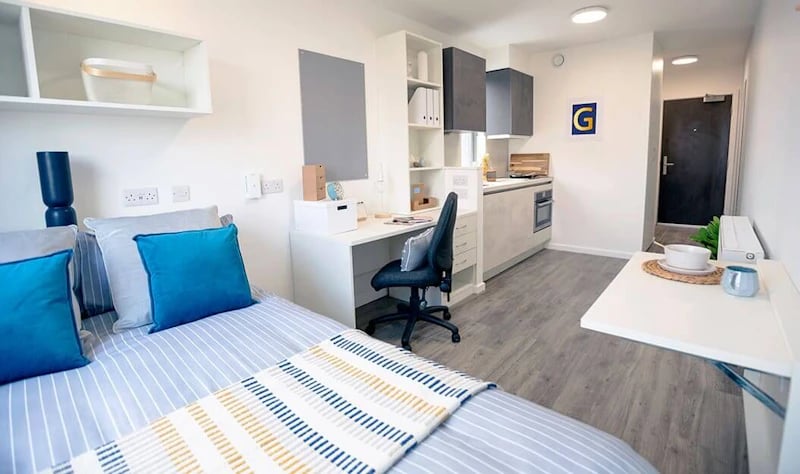 Bed desk kitchen and door Studio apartment at Westcombe House in London Student Accommodation