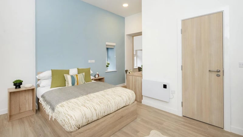 Bed with pillows side table and door bedroom at Westcombe House in London Student Accommodation