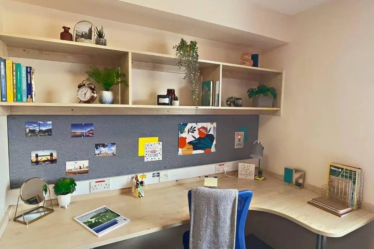Desk with bulletin board and shelves study area at Don Gratton House in London Student Accommodation