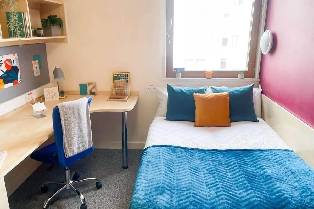 Desk chair bed with blue teal and orange bedding Bedroom at Don Gratton House in London Student Accommodation
