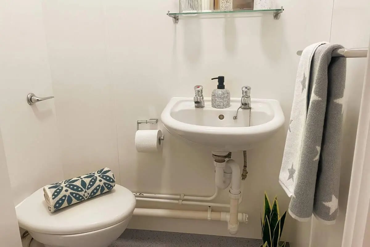 Toilet sink and towel hanging bathroom at Don Gratton House in London Student Accommodation