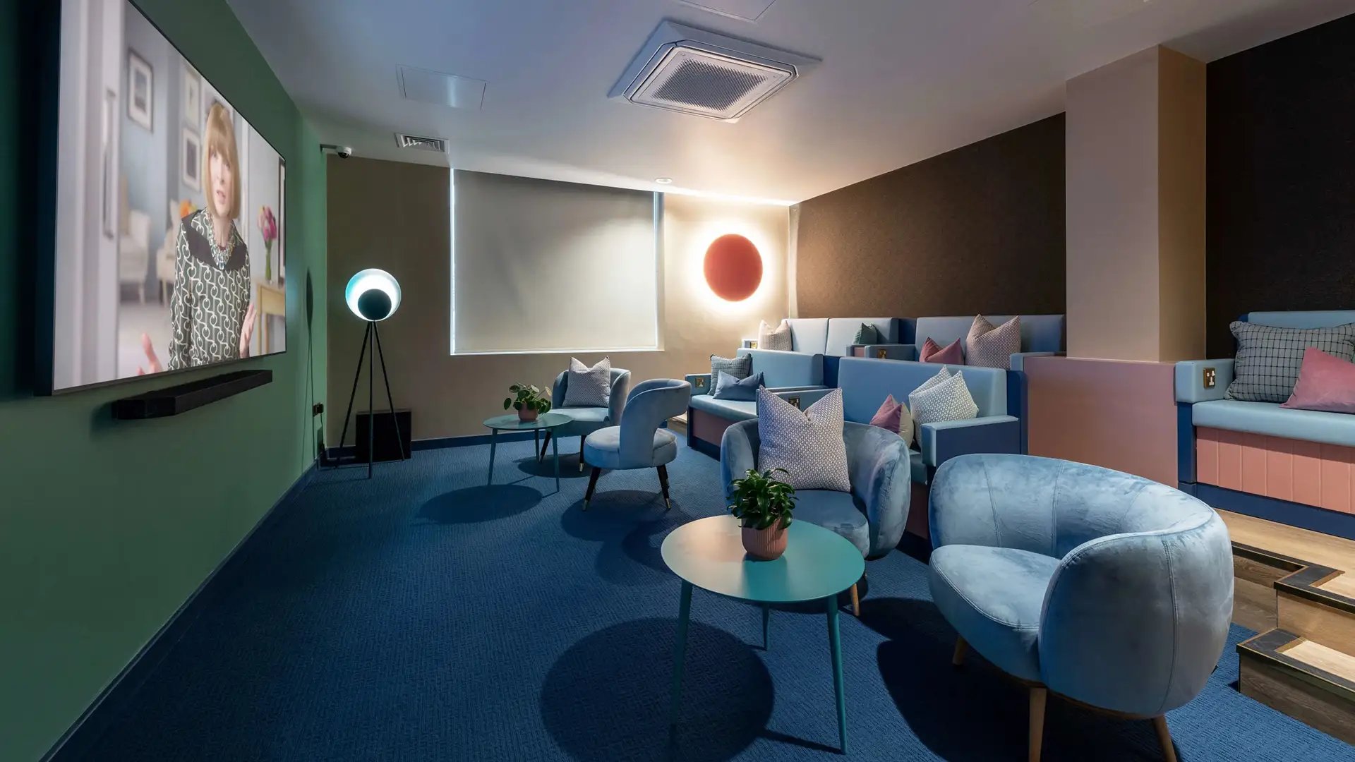 Chairs couches screen and tables cinema room at Wick Park in London Student Accommodation