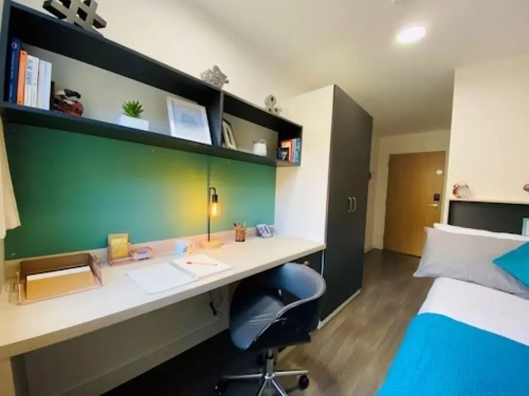 Desk with lamp shelves and bed Bedroom at Mannequin House in London Student Accommodation