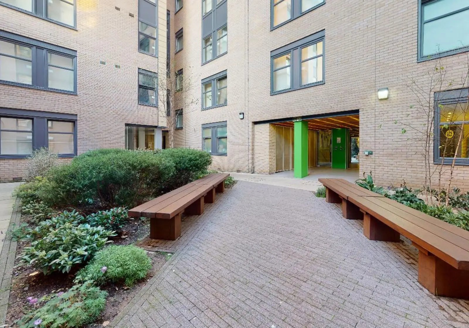 Courtyard with benches and greenery exterior at iQ Tufnell House in London Student Accommodation