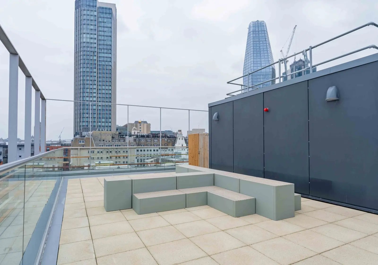 Modern L-shaped bench seating on rooftop patio exterior at iQ Paris Gardens in London Student Accommodation