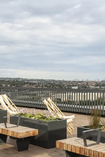 Deck chairs and planters on a balcony exterior at ARK Wembley in London Student Accommodation