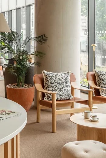 Two leather chairs patterned pillow coffee cups living area at ARK Wembley in London Student Accommodation