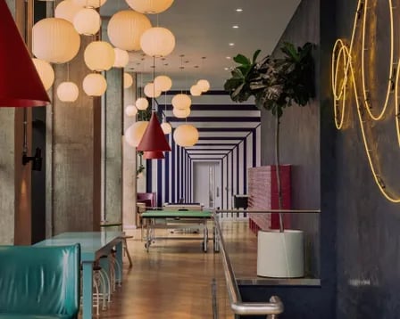 Ping pong table neon sign and dining area communal space at Scape Wembley in London Student Accommodation