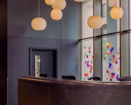 Curved desk and hanging lights Reception at Scape Wembley in London Student Accommodation