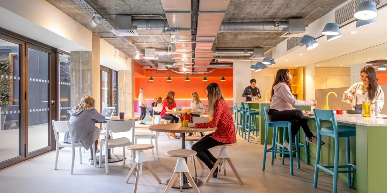 Students in common area with kitchen and seating at Scape Wembley in London Student Accommodation