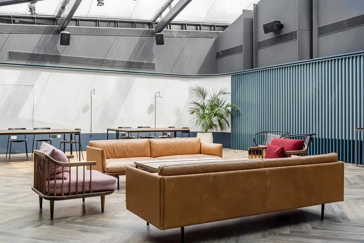 Leather sofas armchair plants and tables communal area at Chapter Spitalfields in London Student Accommodation