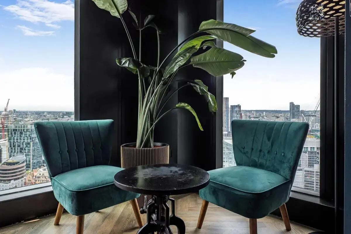Two teal chairs and plant living room at Chapter Spitalfields in London Student Accommodation