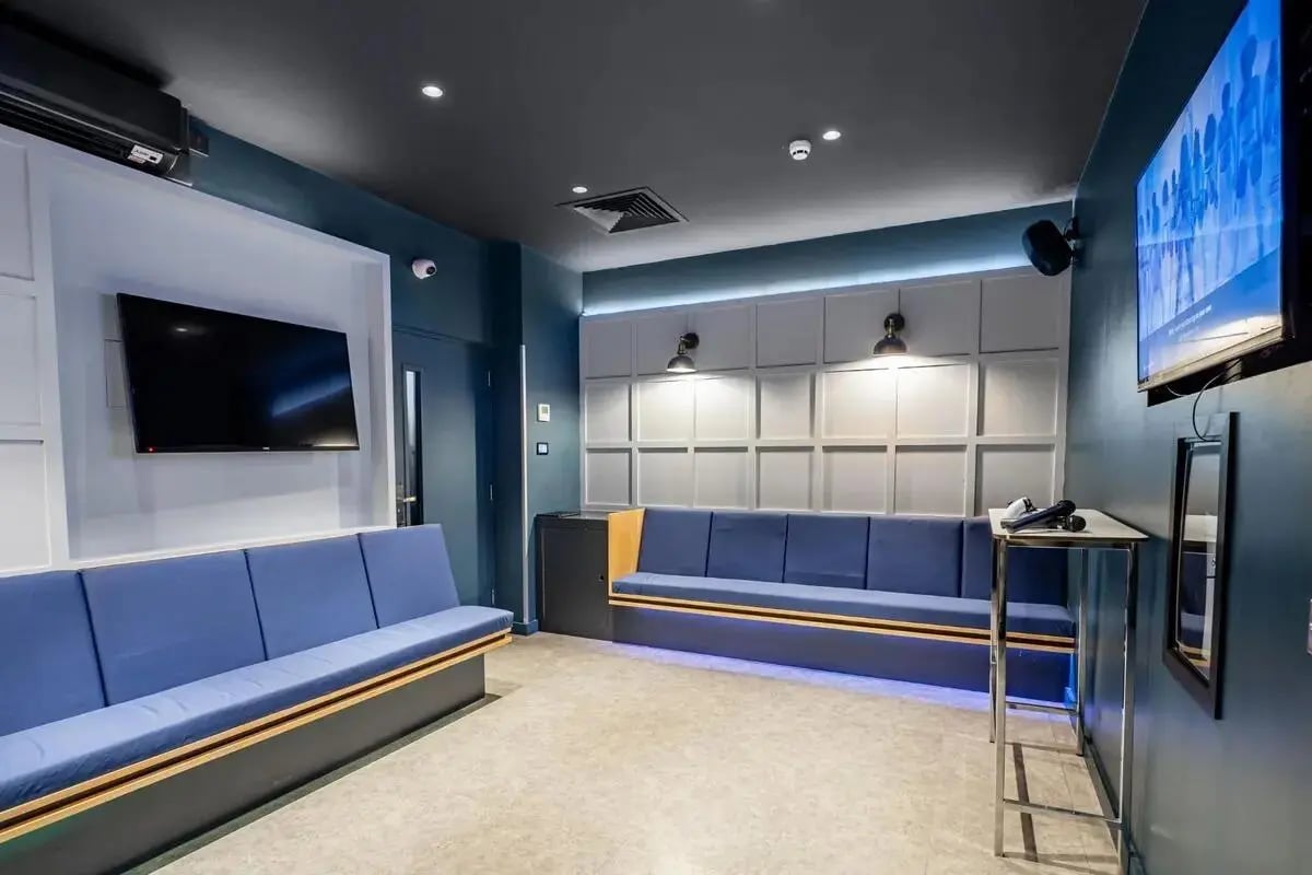 Blue couches TV microphone and speaker living room at Chapter Spitalfields in London Student Accommodation