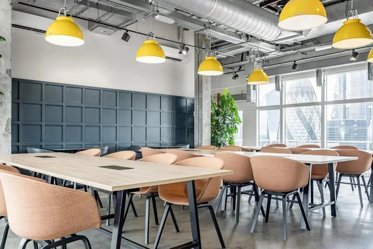 Workspaces with desks chairs and pendant lights communal area at Chapter Spitalfields in London Student Accommodation