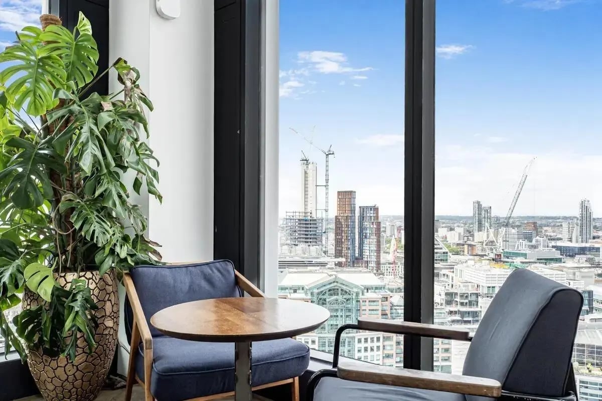 Chairs plant table city view living room at Chapter Spitalfields in London Student Accommodation