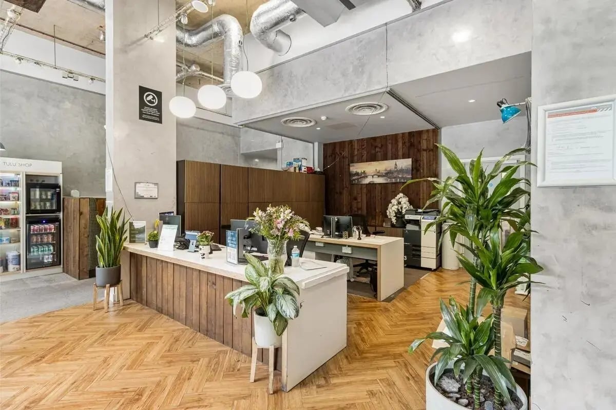 Reception desk with plants and computers reception area at Chapter Islington in London Student Accommodation