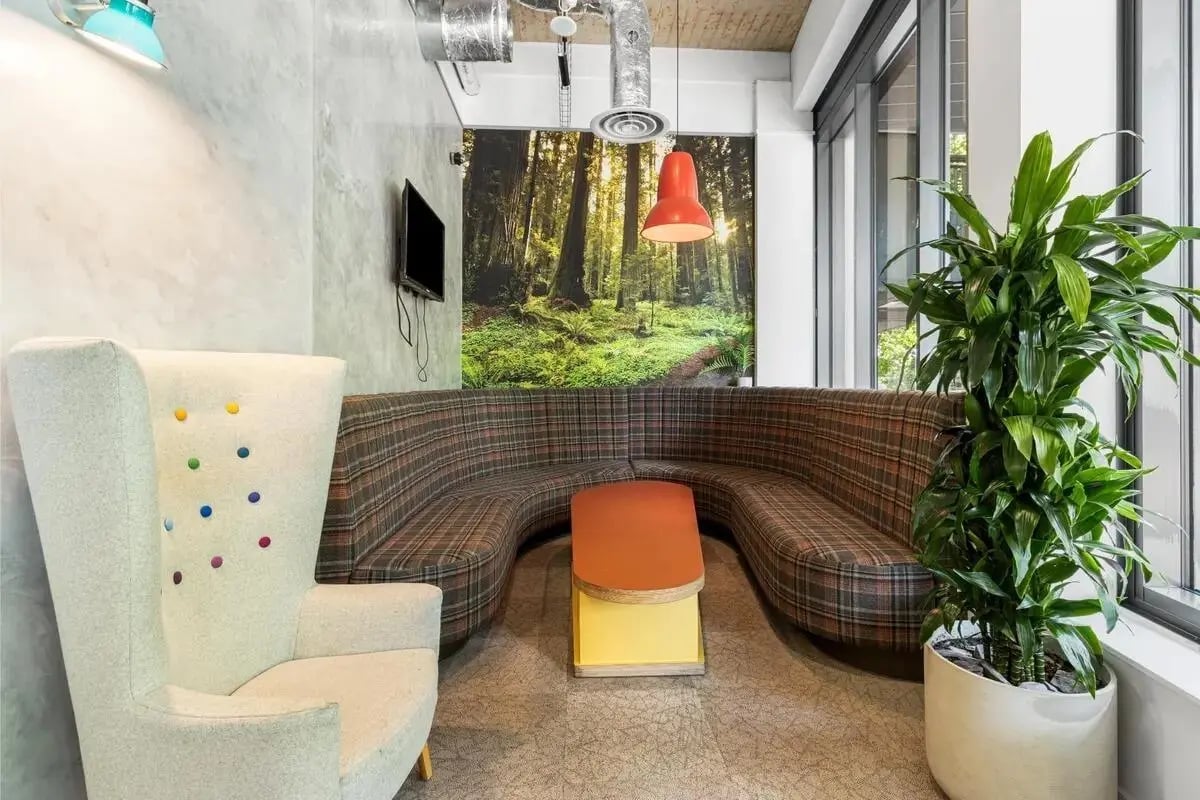 Modern lounge with plaid sofa and plants living room at Chapter Islington in London Student Accommodation
