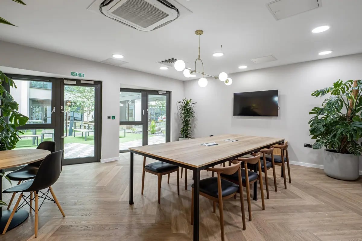 Dining table with chairs near glass doors Common area at Chapter Old Street in London Student Accommodation